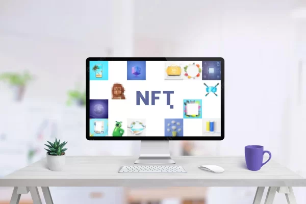 Computer display on work desk with NFT art concept
